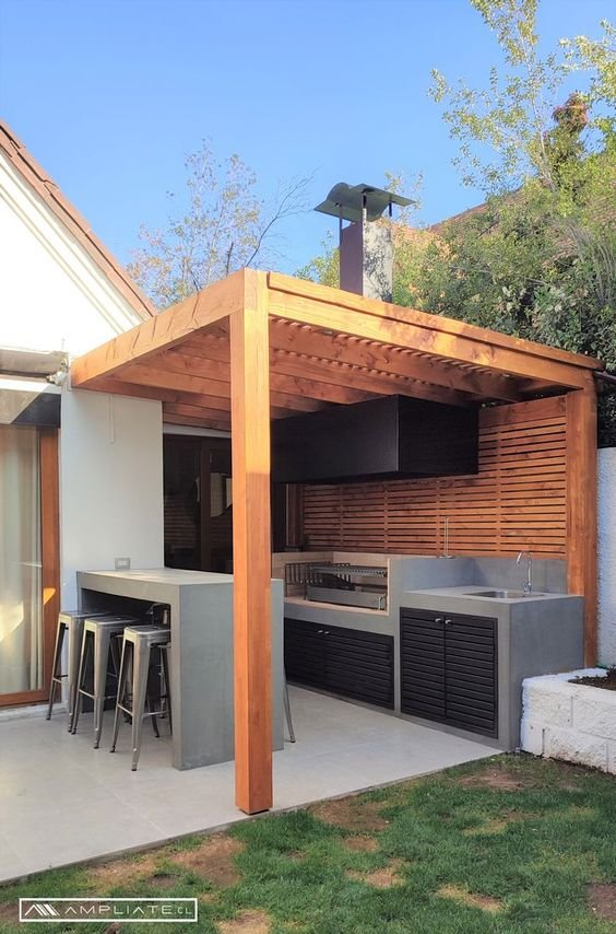 Asador en patio pequeno bajo pergola de madera