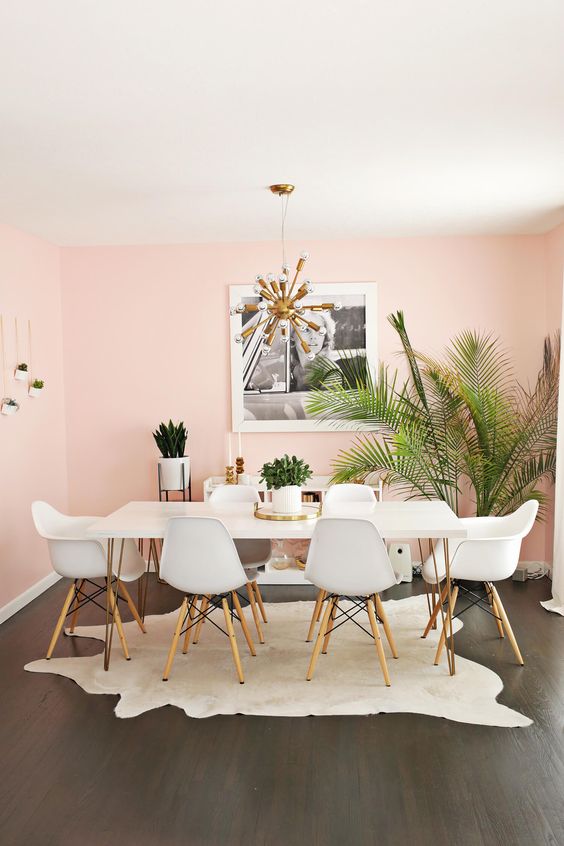 comedor con paredes pintadas de rosa y muebles blancos