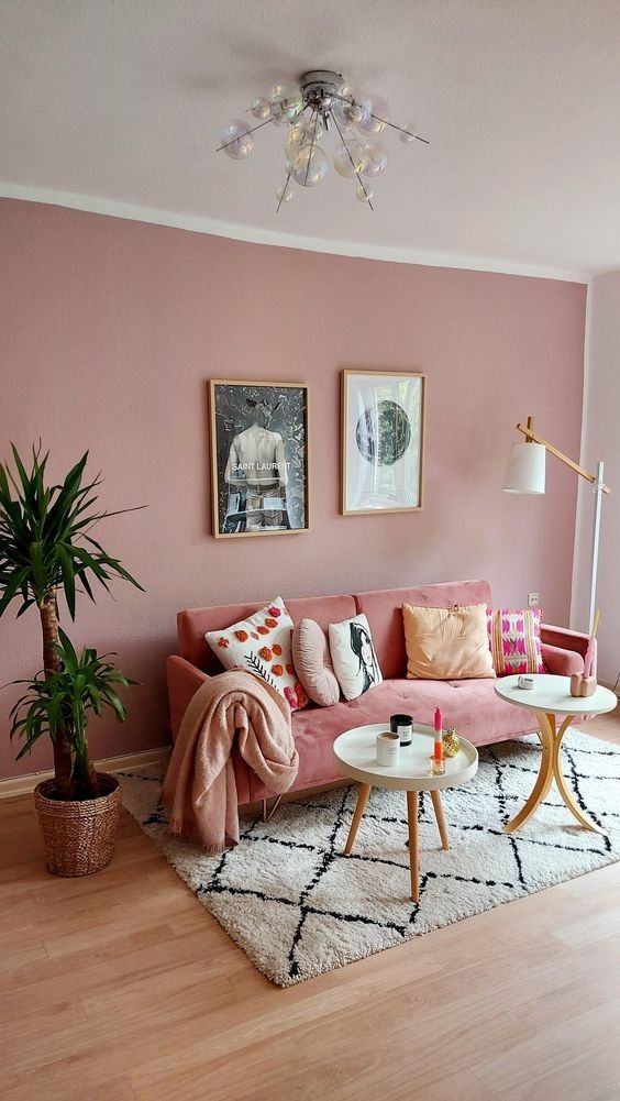 sala de estar con paredes rosas y sillon rosa