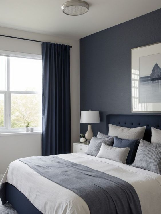 Dormitorio con paredes pintadas azul oscuro y blanco