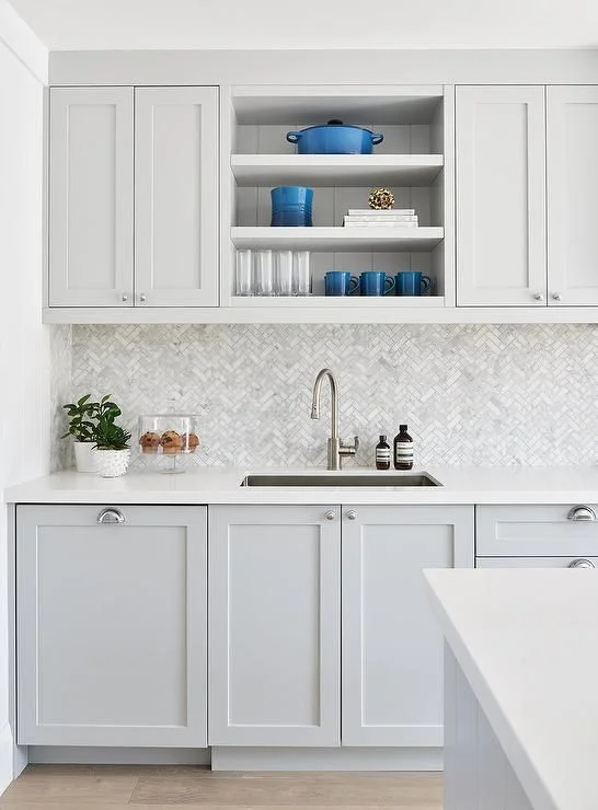 Cocina gris claro revestimiento tonos grises y mesada blancas