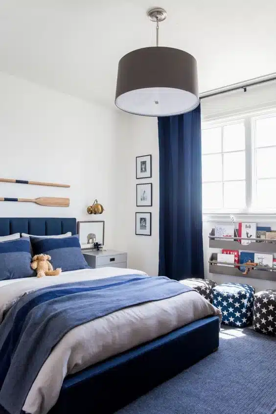 Dormitorio con pared marfil y decoracion azul marino