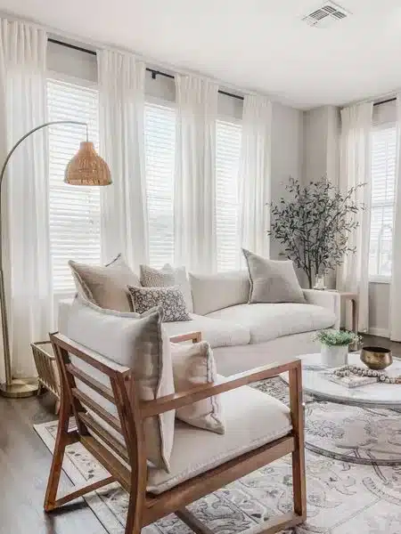 Sala de estar con pared marfil con sofa y cortinas en blanco