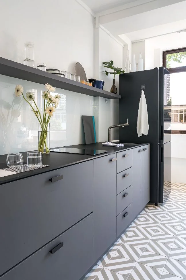 Cocina pequeña con mueble gris oscuro mesada negra y revestimiento blanco