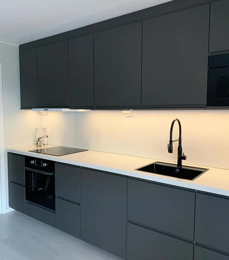 Cocina pequeña con mueble gris oscuro mesada y revestimiento blanco