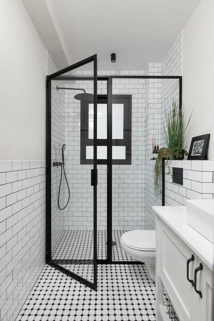 baño pequeño en blanco y negro ducha con mampara bordes negros